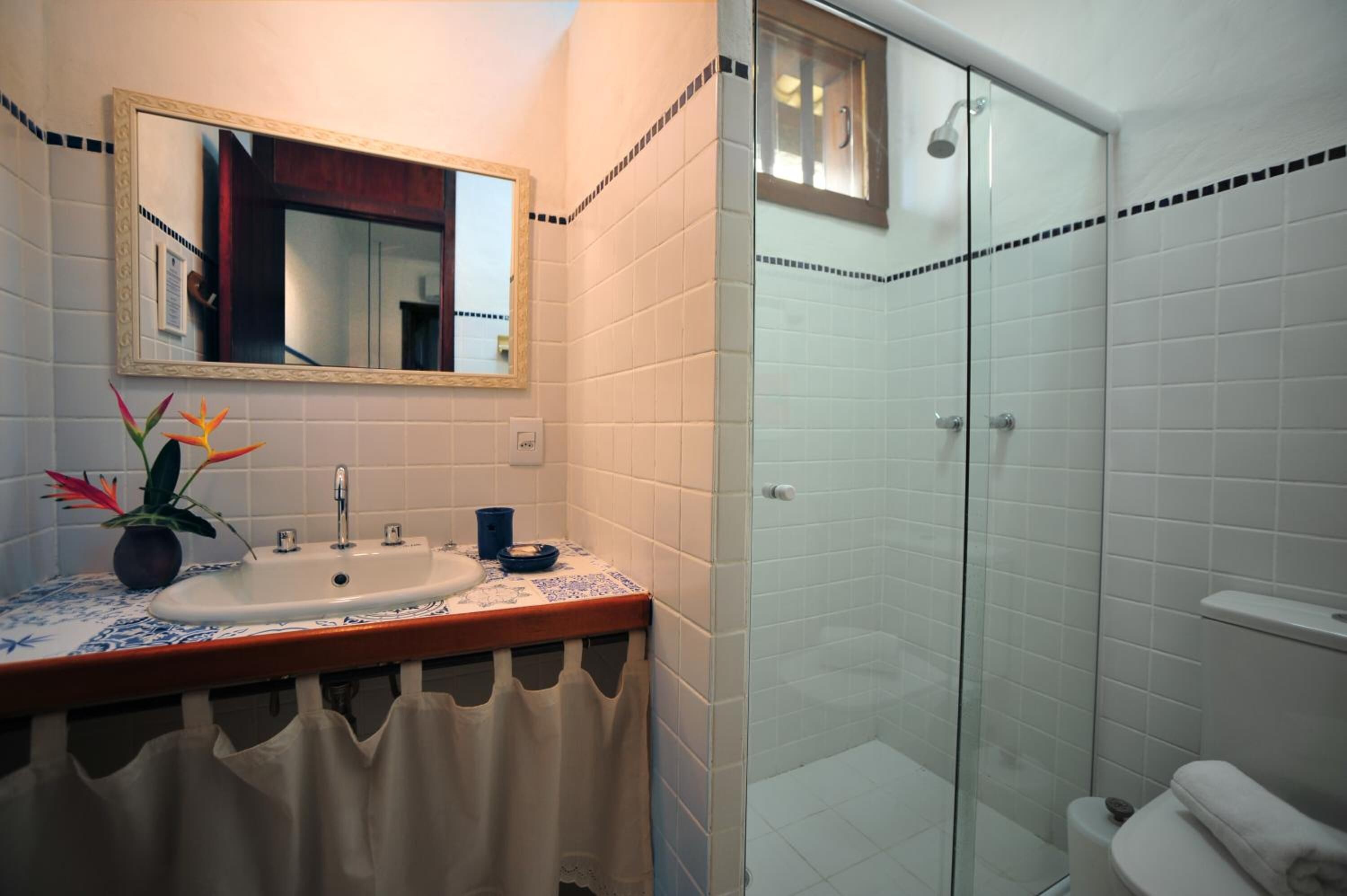 Une salle de bain avec un lavabo, un miroir et une douche.