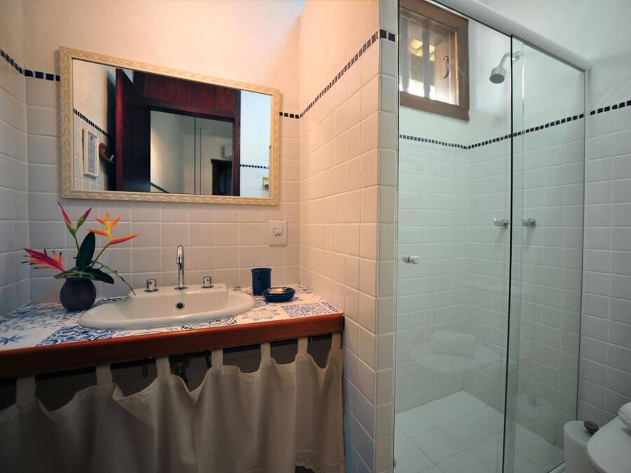 Une salle de bain avec un lavabo, un miroir et une douche.