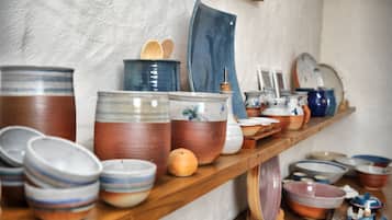 A wooden shelf with various ceramic containers and bowls.