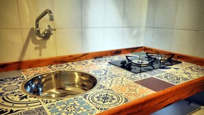 Una cocina con un lavamanos de acero inoxidable, una estufa a gas y un salpicadero con diseño.