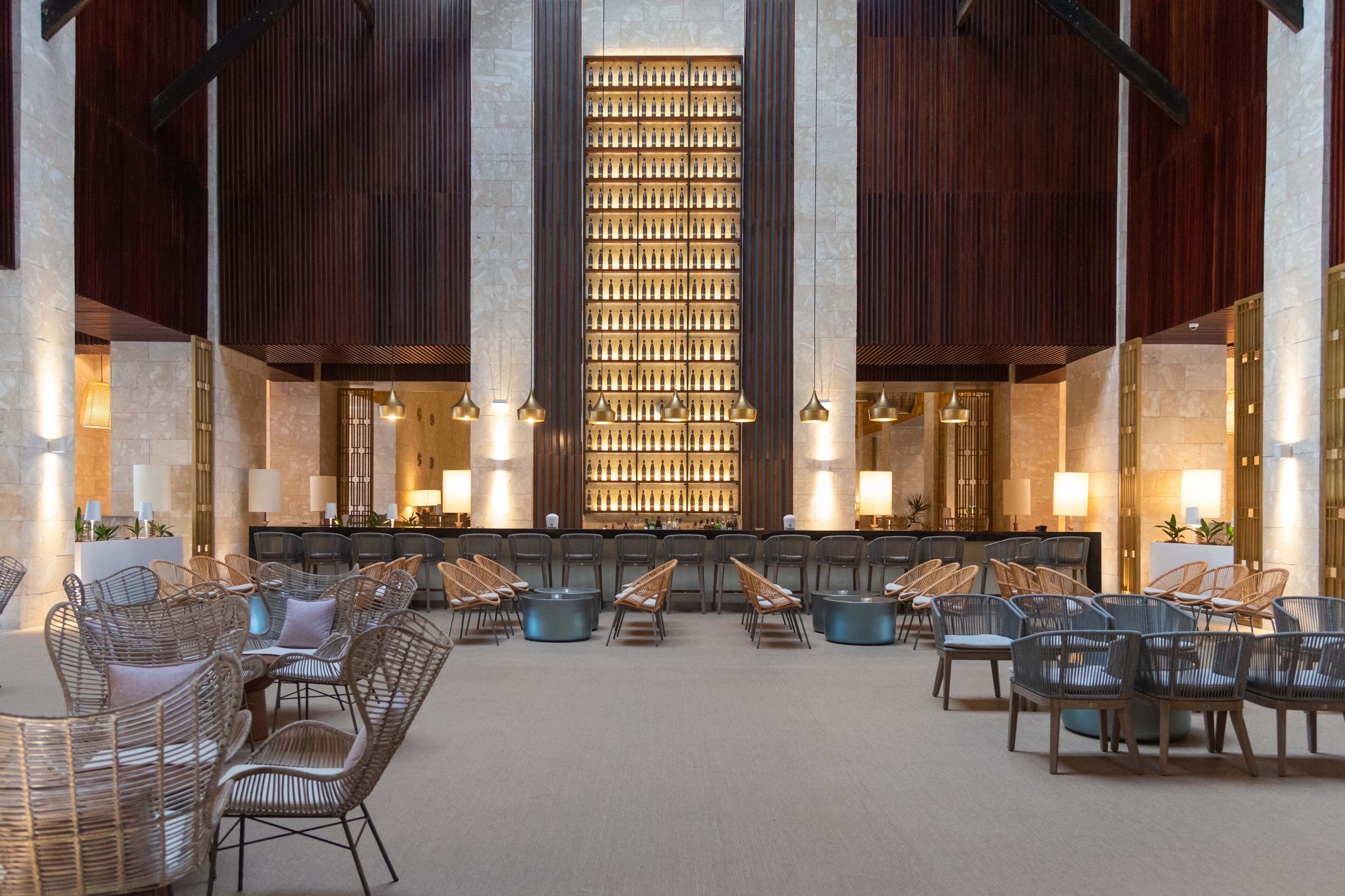 A lobby with a central bar area, seating arrangements, and a decorative wall.