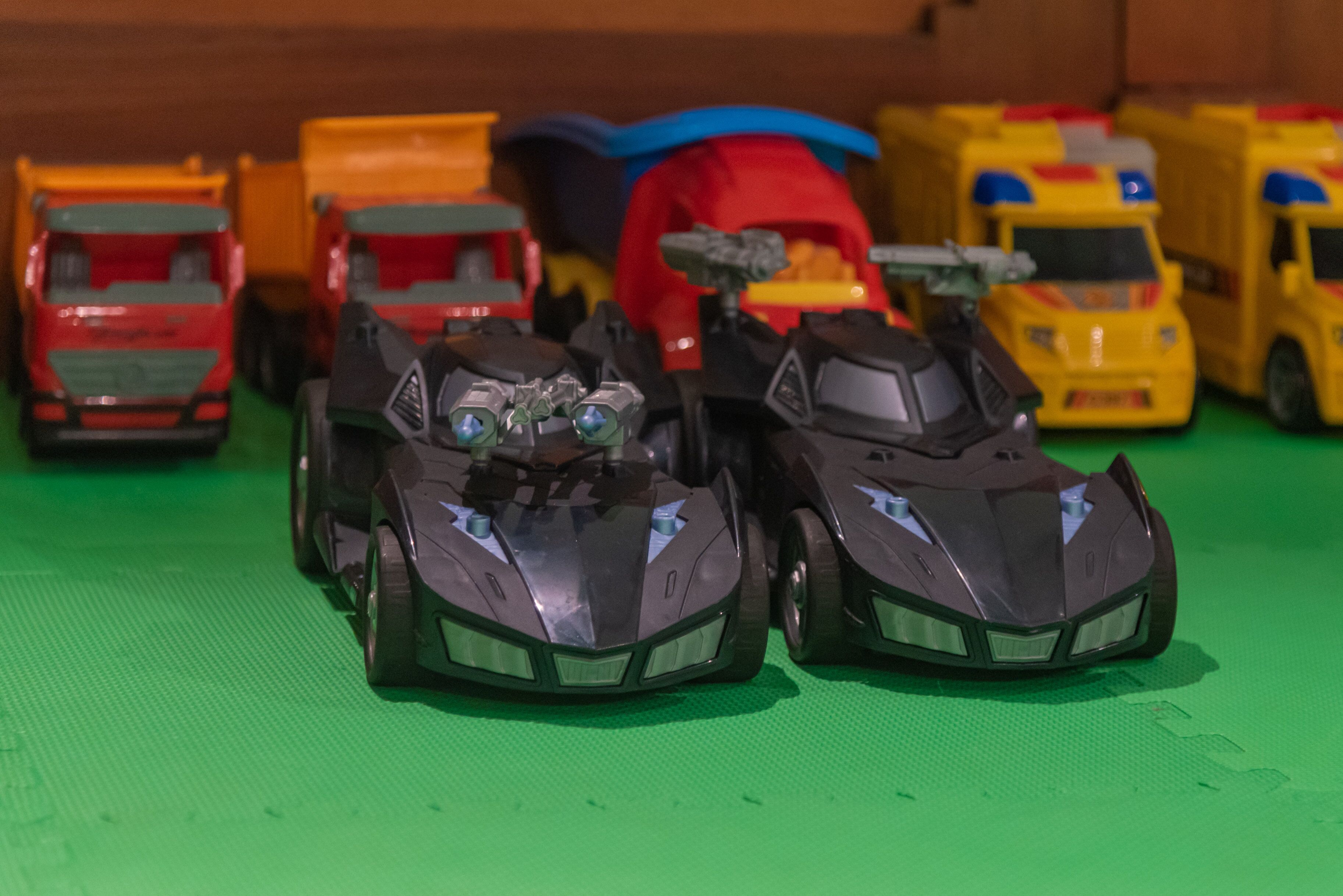 A collection of toy vehicles on a green surface.