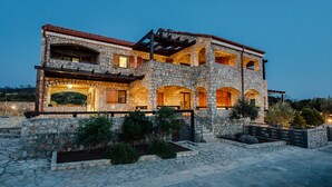 A multi-story stone building with arched windows and a stone facade.