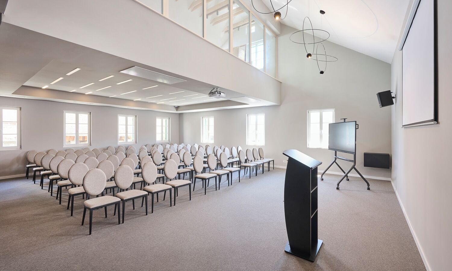 A conference room with rows of chairs, a podium, a projector, and a whiteboard.
