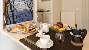 A breakfast table with croissants, a pitcher, a coffee maker, and fruit. - Art&B.E.D.S. (Naples)