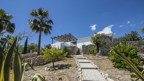 A stone pathway leading to a white building with a pergola, surrounded by palm trees and cacti. - Villa Angel | 2 Bedrooms | Panoramic Views | Parragil (Loulé)