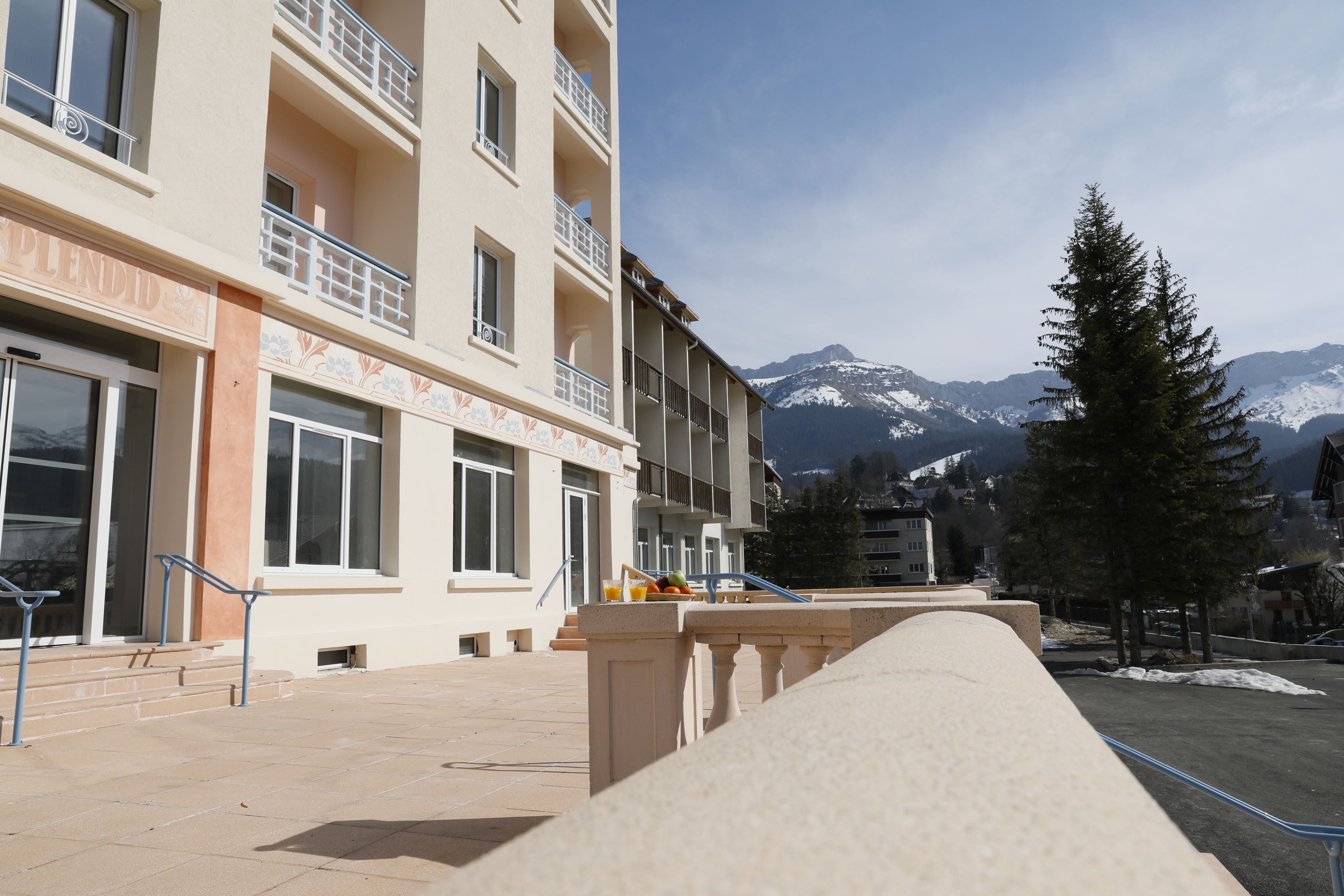 A hotel with a balcony, a mountain view, and a snow-covered landscape.