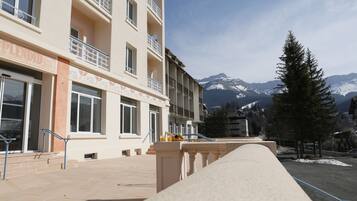 A hotel with a balcony, a mountain view, and a snow-covered landscape.