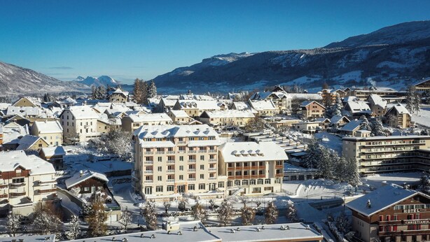 A snow-covered town with a prominent hotel named "Hotel Christiania" featuring a central building with multiple floors and balconies. - Residence Le Splendid (Villard-de-Lans)