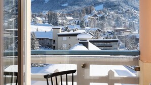 A balcony with a view of a snow-covered mountain and buildings. - Residence Le Splendid (Villard-de-Lans)