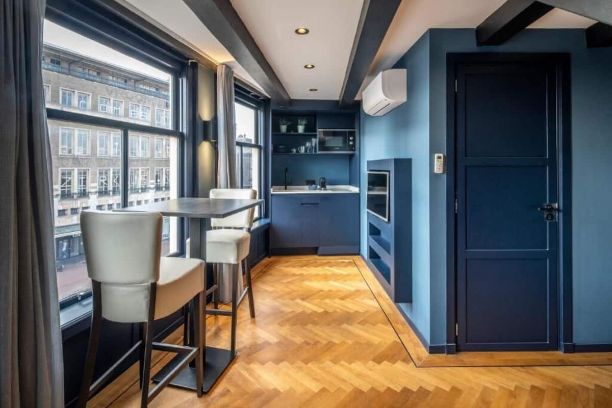 A modern kitchen with a built-in microwave, a sink, and a window overlooking a cityscape.