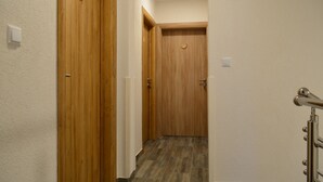 A hallway with wooden doors and a tiled floor. - Natura Plitvice Lakes (Plitvicka Jezera)