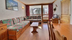 A cozy room with a wooden sofa, a wooden table, and a bench. - 10m from ski slopes, Ground floor, balcony, 40m², Méribel-Mottaret (Méribel - Les Allues)