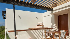 An outdoor seating area with a wooden table and chairs, a sofa with patterned cushions, and a pergola with hanging lights. - Romantic Penthouse Studio Get Away With Private Splash Pool- PENT HOUSE 3 B- By Salt-Kisses (Tulum)