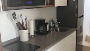 A modern kitchen with a microwave, coffee maker, and utensils on the counter. - Romantic Penthouse Studio Get Away With Private Splash Pool- PENT HOUSE 3 B- By Salt-Kisses (Tulum)