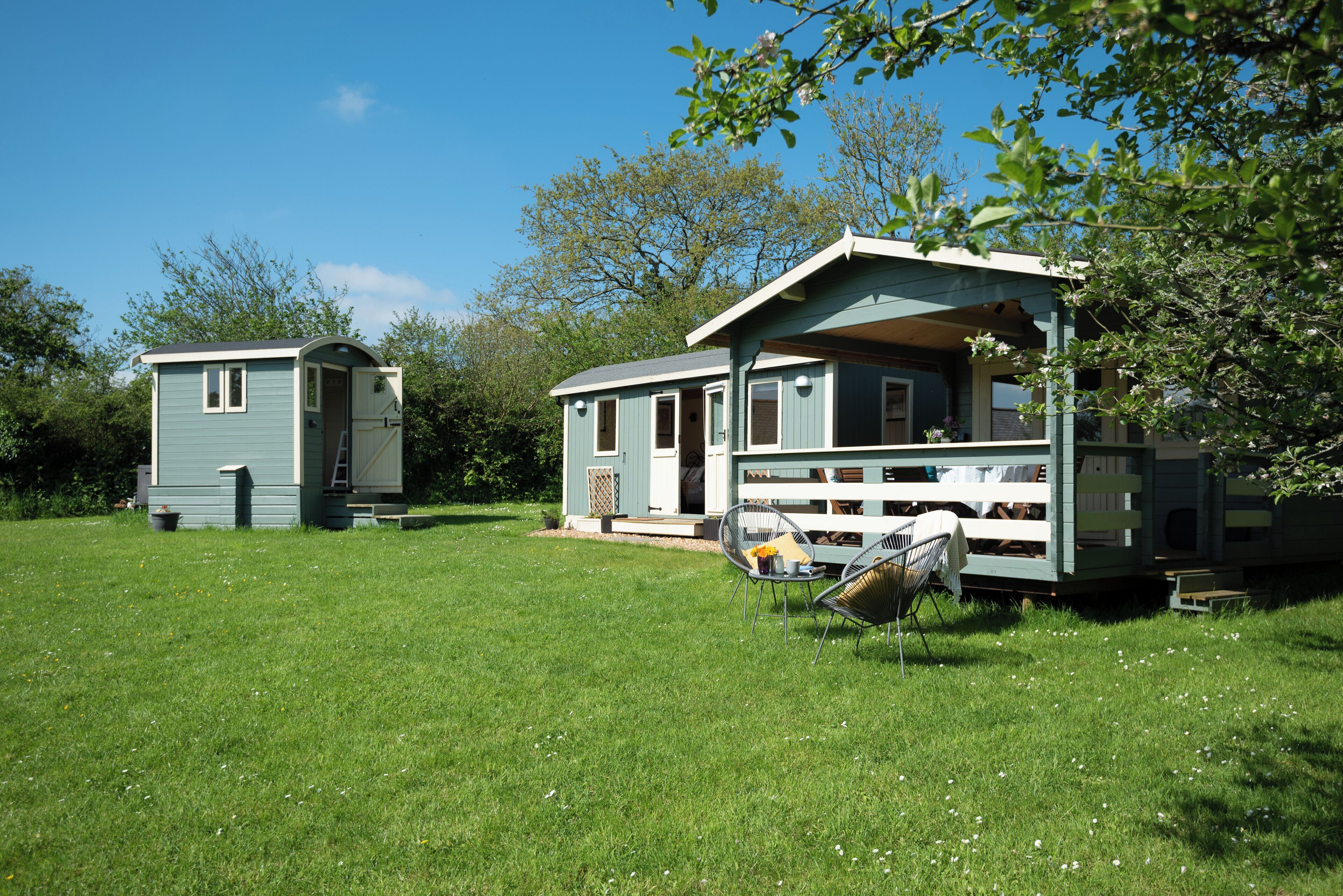 A mobile home with a porch and a small attached structure.