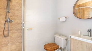 Une salle de bain avec des toilettes, une douche et un lavabo.