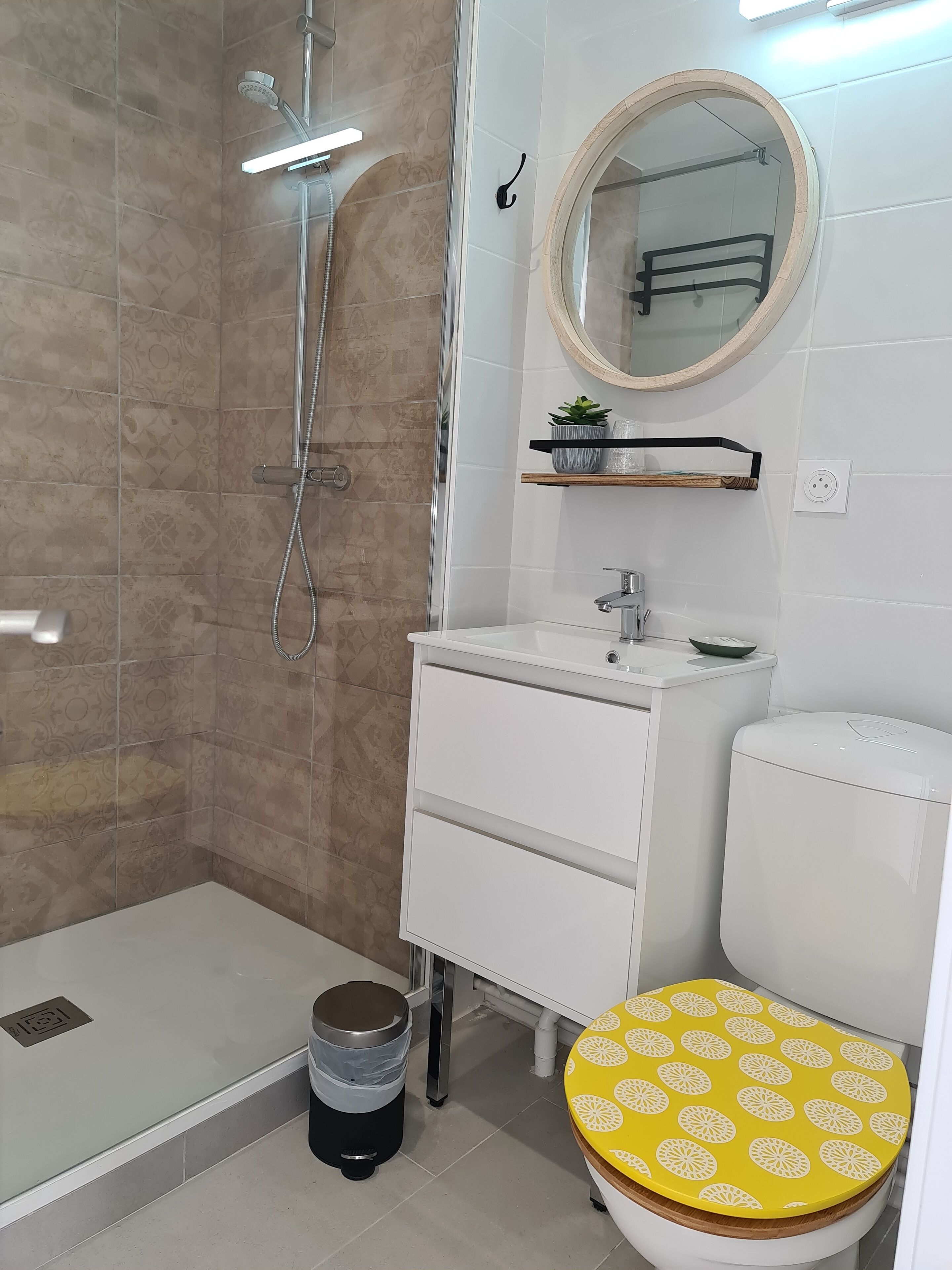 Un baño con ducha, inodoro, lavamanos y espejo.