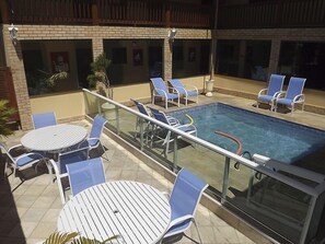Una piscina al aire libre, tumbonas
