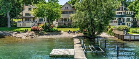 A lakeside property with a dock, a grassy area with chairs, and a large house labeled 'Grand View.'