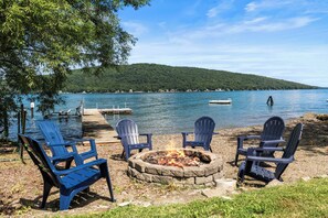 Un cadre idyllique au bord du lac, avec un foyer et des fauteuils Adirondack.