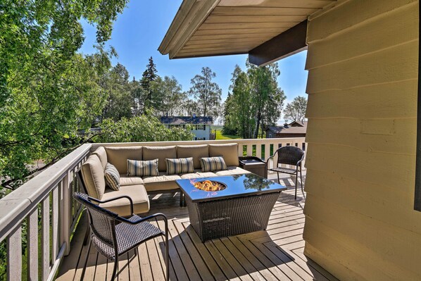 An outdoor deck with a sofa, chairs, and a table. - Theater Room + Fire Pit: Anchorage Family Retreat (Anchorage)