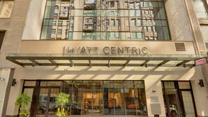 La façade extérieure de l’hôtel Hyatt Centric est en verre et reflète les bâtiments environnants.