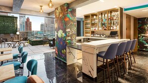 Un espace bar moderne avec vue sur la ville, des tabourets de bar et un assortiment de bouteilles.