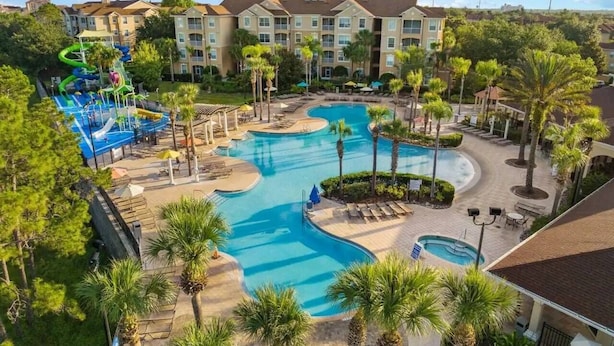 Un resort con varias piscinas, parque acuático y un edificio con balcones.