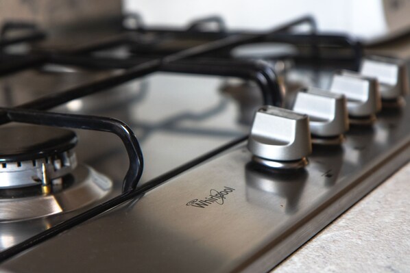 A stainless steel Whirlpool gas stove with four burners and a control knob.