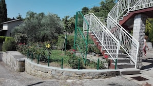 A garden with a metal staircase and a stone wall. - Very Spacious Apartment (Izola)
