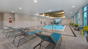 Zona de piscina con sillas de descanso, una piscina y vistas al exterior.