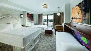 A hotel room with a large bed, a sofa, a desk, and a view of the outdoors.