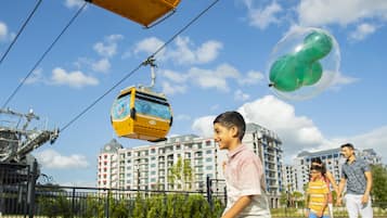 A cable car system, a large building complex, and a group of people.