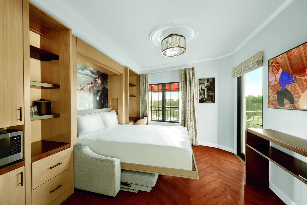 A bedroom with a bed, built-in wardrobe, and a television.