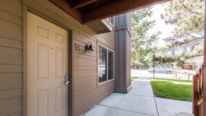 A residential building with a beige exterior, a front door, and a small porch area.