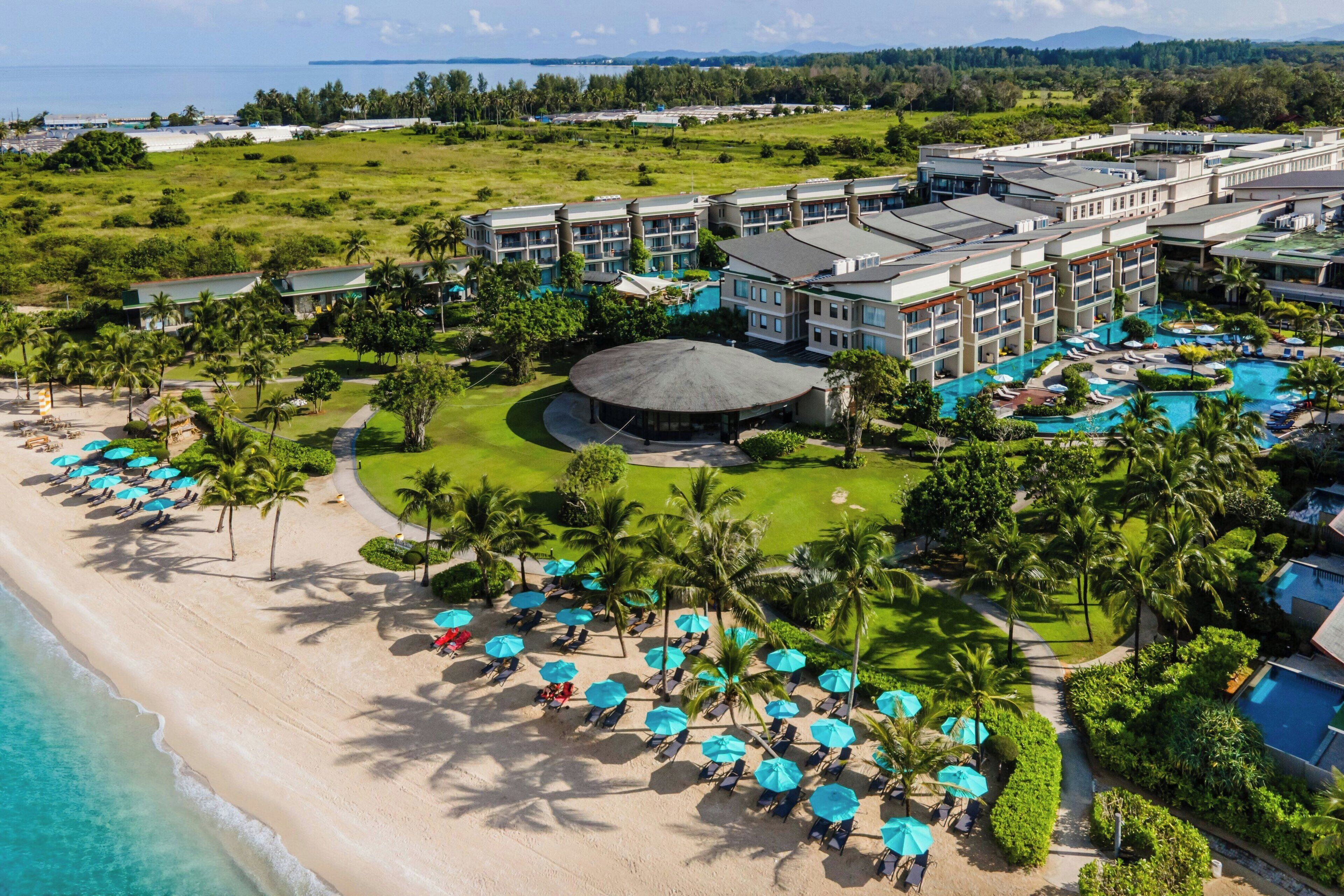 A resort with a beach, a pool area, and multiple buildings.