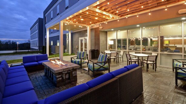Un espace extérieur aménagé avec une terrasse, des sièges et un foyer.