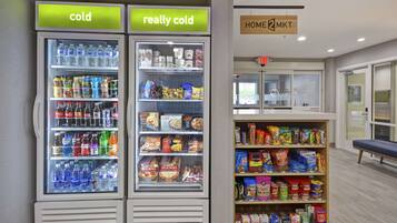 Two refrigerated beverage dispensers labeled "cold" and "really cold," and a shelf stocked with snacks and beverages.