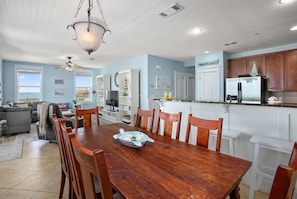 A spacious kitchen with a wooden dining table, white cabinets, and a refrigerator. - Time Away Book 5+ nights & get 15% discount-Near Lazy River-3BD/2BA. Sleeps 9 (Galveston)