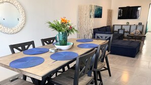 A dining area with a wooden table, blue placemats, and black chairs.