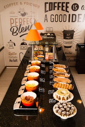 A coffee station with various pastries and a coffee machine.