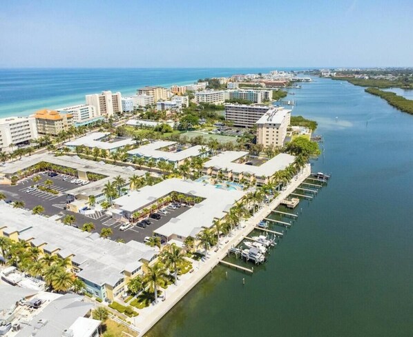 A coastal hotel area with multiple buildings, a marina, and a river.