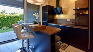 A modern kitchen with a bar area, a large window, and a view of the outdoors. - Amazing luxury apartment 200 m from the beach (Pula)
