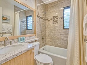 A bathroom with a marble sink, a toilet, and a bathtub. - Pacific Views w/Private Lanai – Kaha Lani 208 (LIHUE)