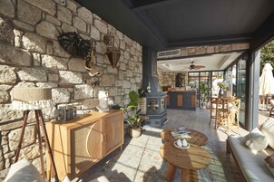 Una habitación con paredes de piedra, un armario de madera, una mesa redonda y un sofá.