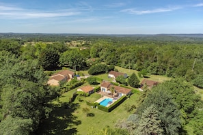 A residential area with houses, a swimming pool, and surrounding greenery. - Grauvière is a lovely holiday home (Anglars-Nozac)