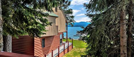 A cabin with a view of a lake and mountains.