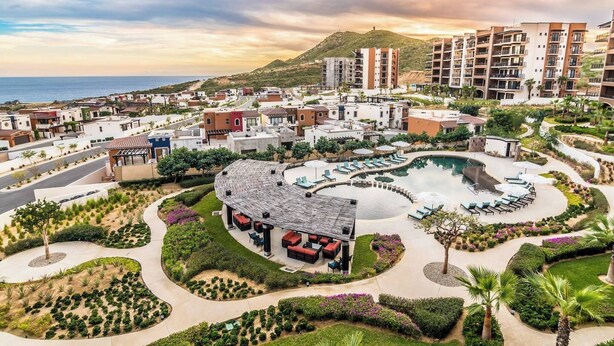 Un resort con piscina, area salotto all'aperto e vista sull'oceano.