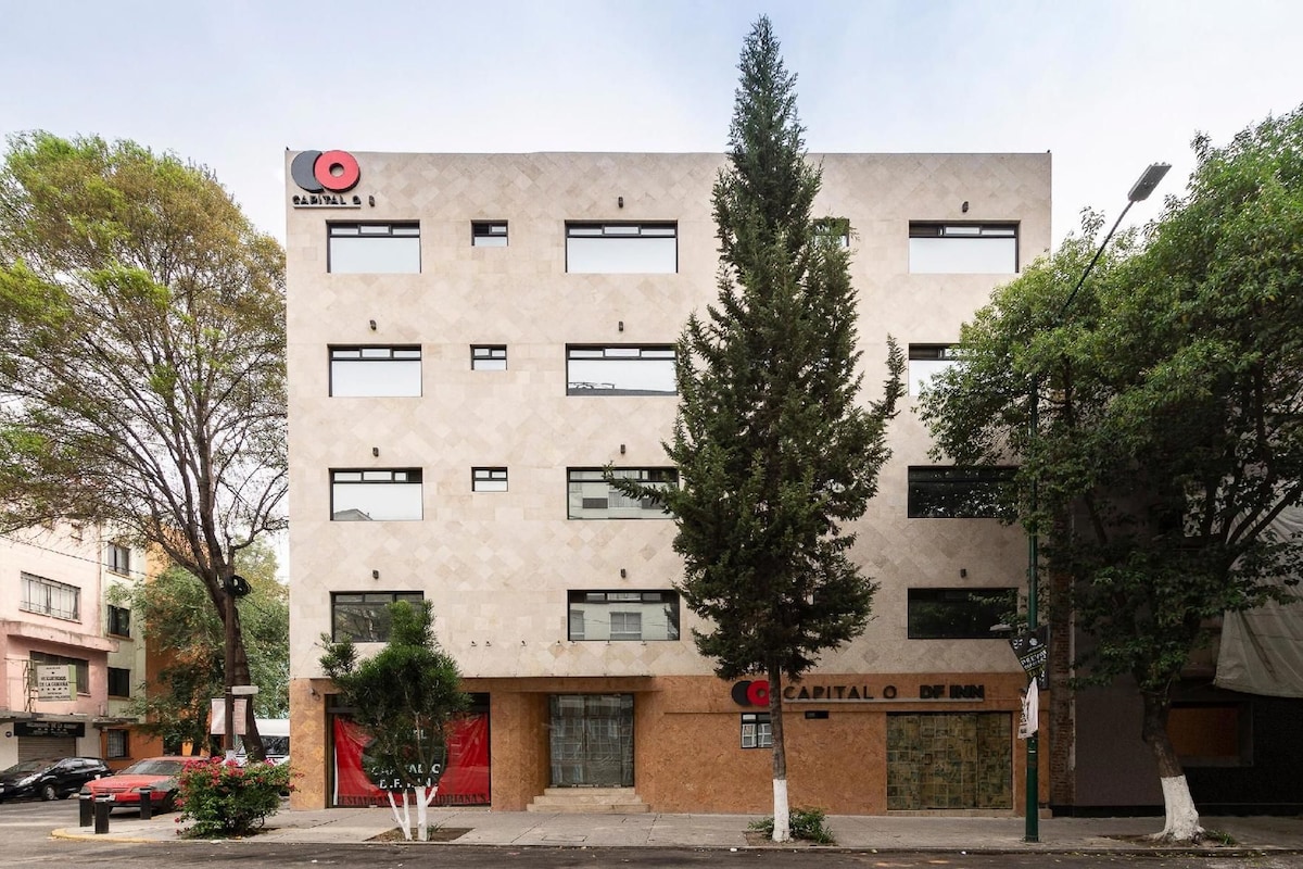A multi-story building with a modern facade, featuring a prominent logo at the top.